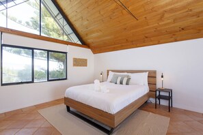 A bedroom with a wooden ceiling, large windows, a bed with white bedding, and a small bedside table with a lamp. - Terrace Heaven – Luxe Retreat in Fremantle (Fremantle)