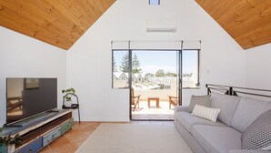 A living room with a TV, sofa, and a view of the outside. - Terrace Heaven – Luxe Retreat in Fremantle (Fremantle)