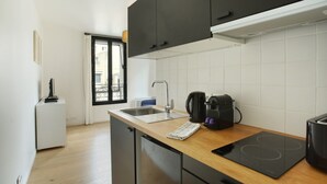 Une cuisine moderne dotée d’un plan de travail en bois, d’un lave-vaisselle encastré, d’une machine à café et d’un grille-pain.