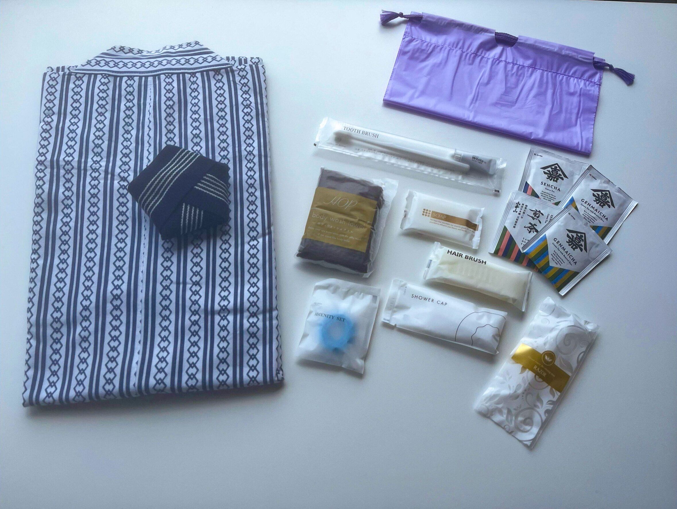 A neatly arranged set of toiletries and a folded garment on a white surface.
