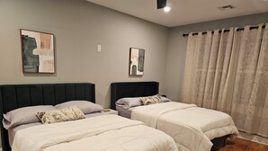 A hotel room with two beds, a wooden floor, and two abstract paintings on the wall. - Deluxe Aparment Spacious 3-bedroom apartment with WiFi, AC in nice Elizabeth (Elizabeth)