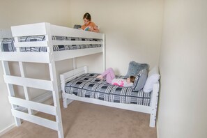 A bunk bed with two levels, a child on the top bunk, and a child on the bottom bunk. - Princess Views in Historic Albany (ALBANY)