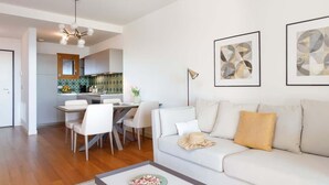 Ein modernes Wohnzimmer mit Sofa, Couchtisch und Essbereich.