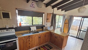 Une cuisine spacieuse avec des meubles en bois, un grand îlot central, un four encastré et un sol carrelé disposé en motif de chevron.