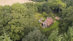 A rural house surrounded by dense forest, with a large field in the background. - Bull Hollow Cottage -  Shrewsbury , Shropshire (Shrewsbury)
