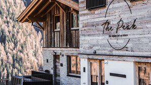A wooden building with a sign reading "The Peak" and a mountain view in the background.