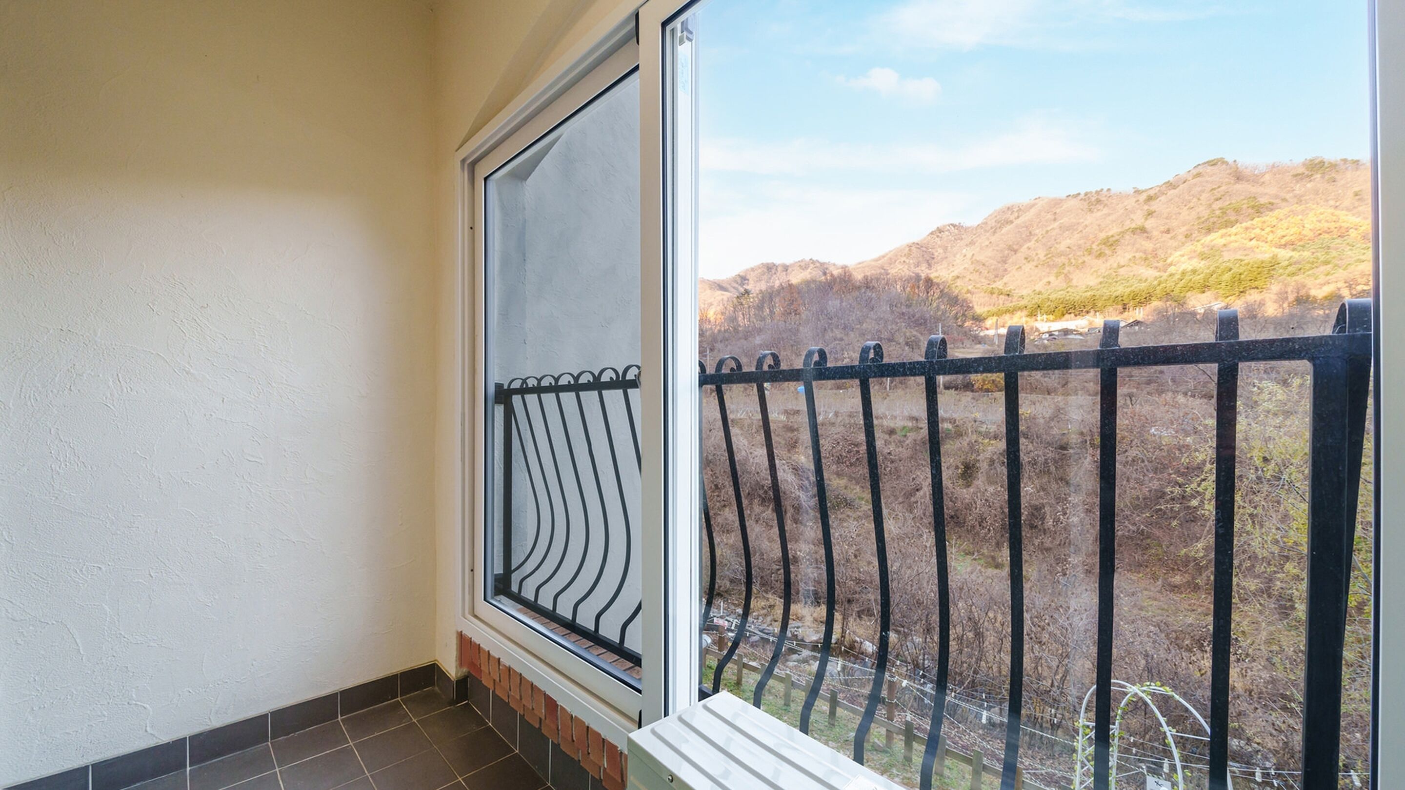 A balcony with a view of a hilly landscape.