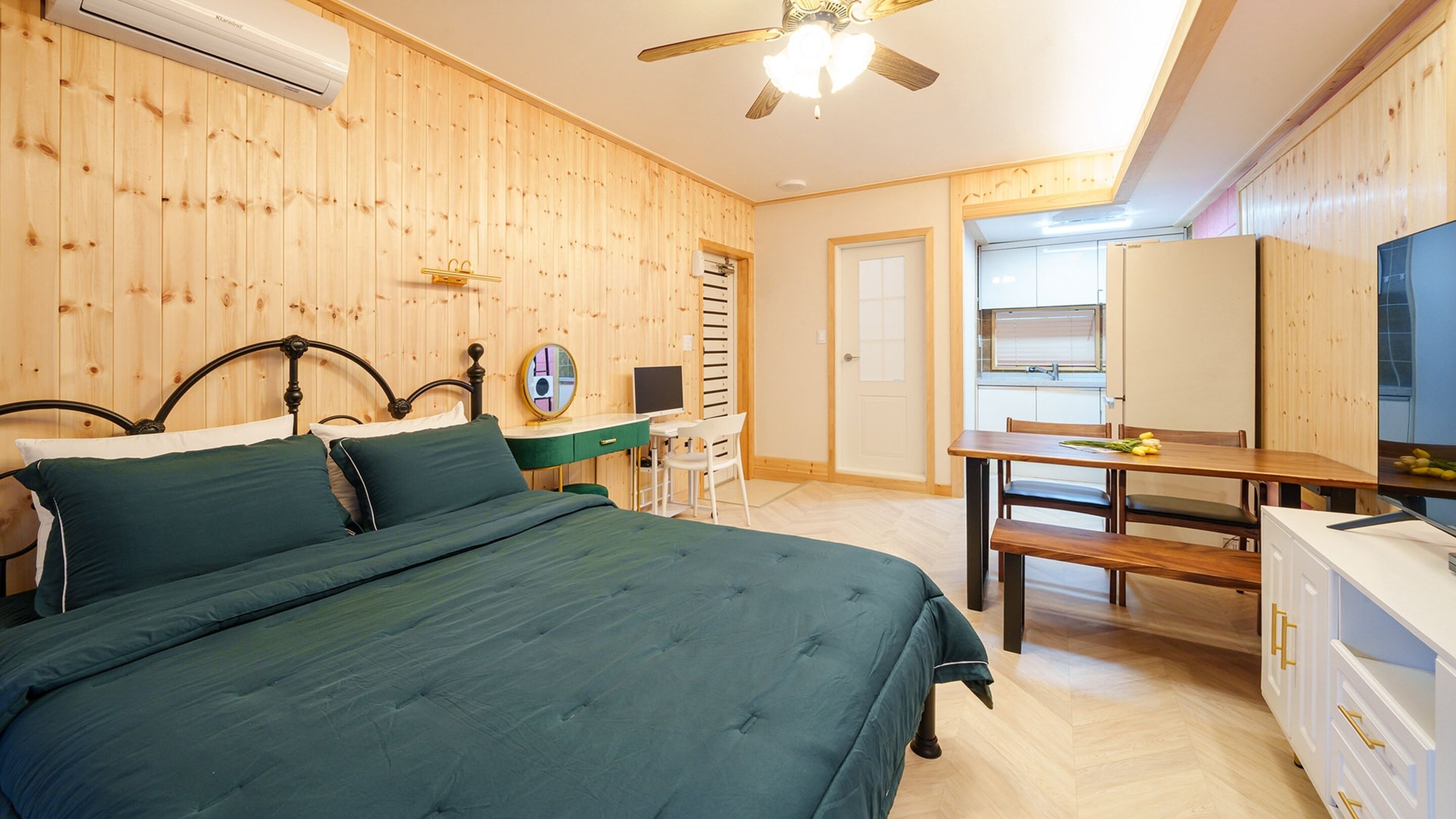 A bedroom with a bed, a desk, and a chair.