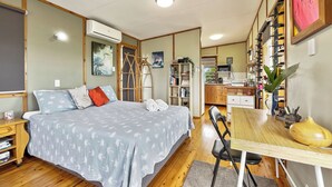 Un dormitorio acogedor con cama, mesita de noche y un espacio de escritorio con silla.