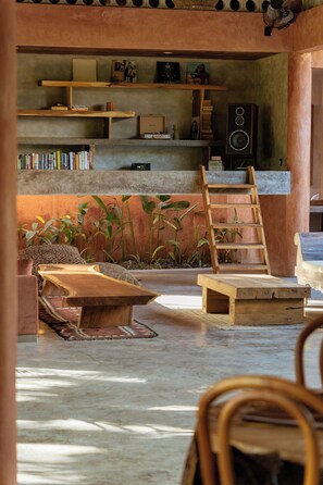 Een gezellige leeshoek met een houten ladder, boekenplanken en een comfortabele zithoek.
