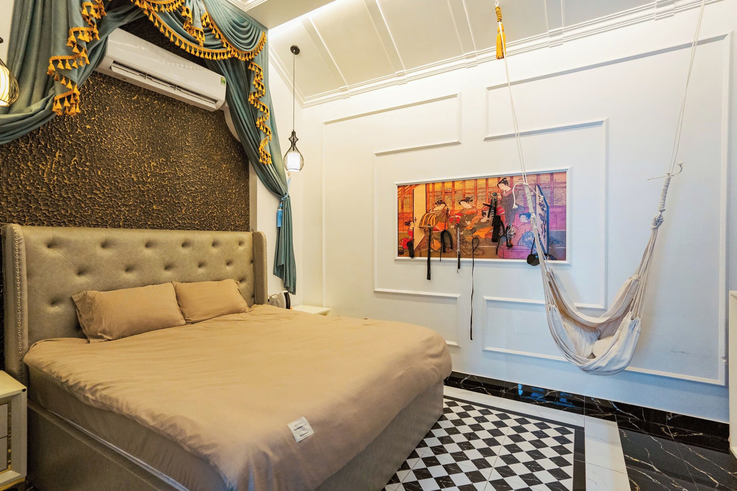 Ein Schlafzimmer mit einem großen Bett, einer Hängematte, einem Gemälde und einem karierten Boden.