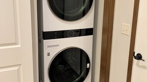 A stacked washer and dryer unit in a narrow hallway. - Perfect Retreat for Comfort and Convenience (Lincoln,)