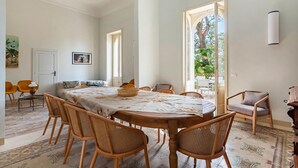 Un coin repas avec une table ronde, des chaises en bois et une nappe à motifs.