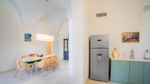 A modern kitchen with a built-in refrigerator, a dining table with chairs, and a kitchen island. - Vallone Apartment S, Galatina, Italy (Galatina)