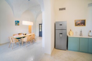 Een moderne keuken met een inbouwkoelkast, een eettafel met stoelen en een keukeneiland.