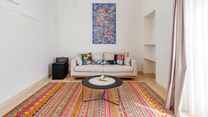 A living room with a sofa, a coffee table, a colorful rug, and a painting on the wall. - Vallone Apartment S, Galatina, Italy (Galatina)