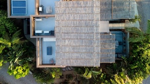 An aerial view of a modern house with a large open patio, a solar panel, and lush greenery surrounding it. - Ocean/Mountain Views home in El Pescadero (El Pescadero)