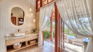 Une salle de bain avec un grand lavabo, un miroir et un meuble-lavabo en bois.