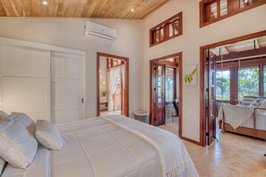 Une chambre à coucher avec un lit, une porte blanche et une vue sur l’extérieur.