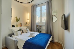 Laptop workspace, iron/ironing board, bed sheets - Modern Studio Arc de Triomphe Monceau (Paris)