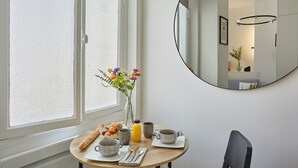 Et morgenbord med en vase blomster, en croissant og en appelsinjuice.
