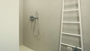 A bathroom with a shower, a white towel rack, and a power outlet on the wall. - Lovely and new Apartment Center of Paris (Paris)