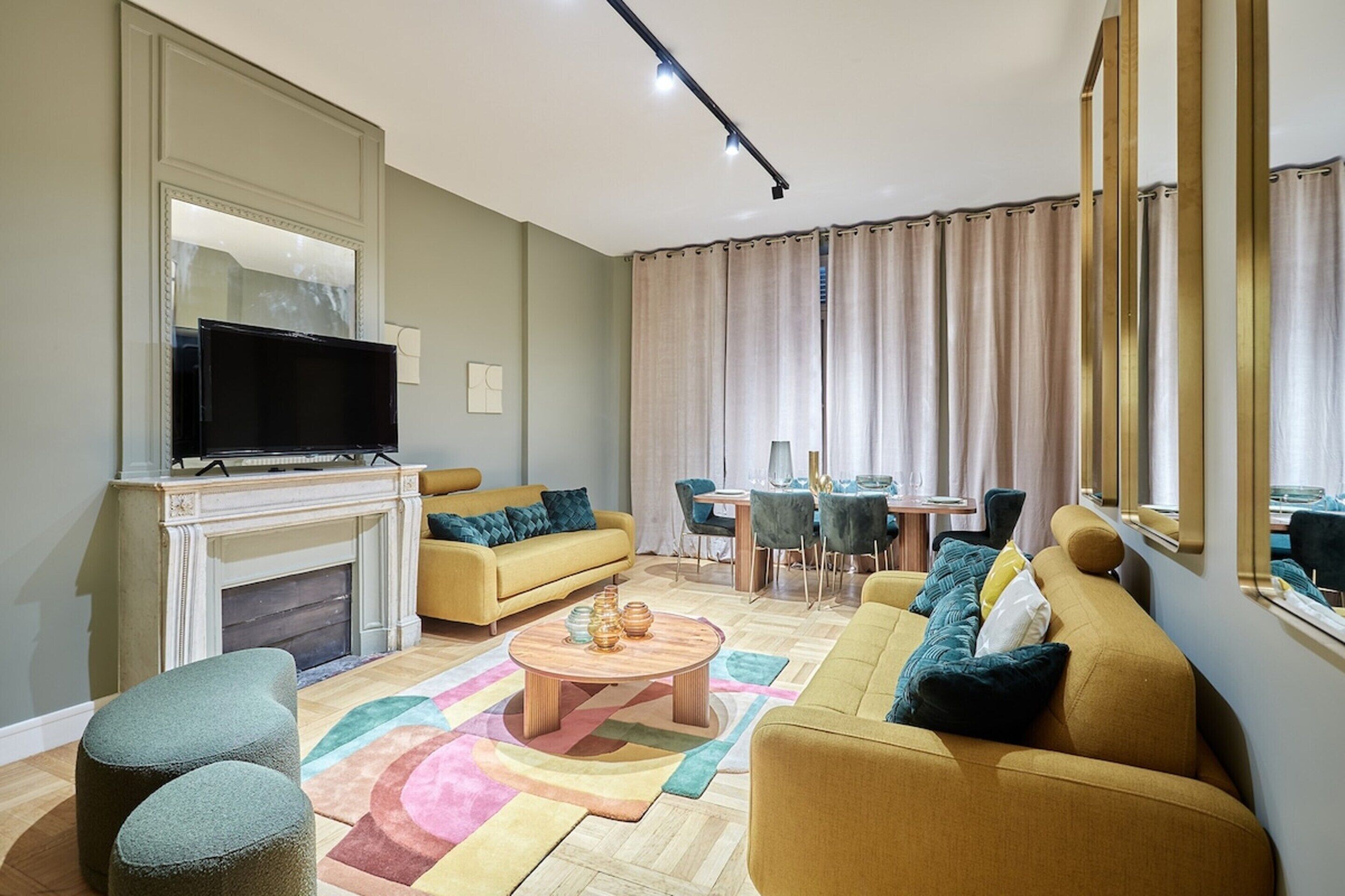 Ein modernes Wohnzimmer mit Kamin, Sofa, Couchtisch und Fernseher.