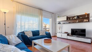 A modern living room with a sofa set, a coffee table, a TV, and a cabinet.