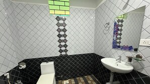 Un bagno con il water, un lavandino e uno spazio doccia.