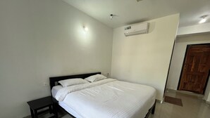 Una camera da letto con un letto, un comodino e un condizionatore d'aria a parete.