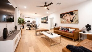 Uma sala de estar moderna com sofá, mesa de centro e área de jantar.