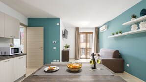 A modern kitchen with a dining table set for two, a microwave, and a small cabinet. - Nice apartment for 4 guests with A/C, WIFI, TV and terrace (Balestrate-foce)