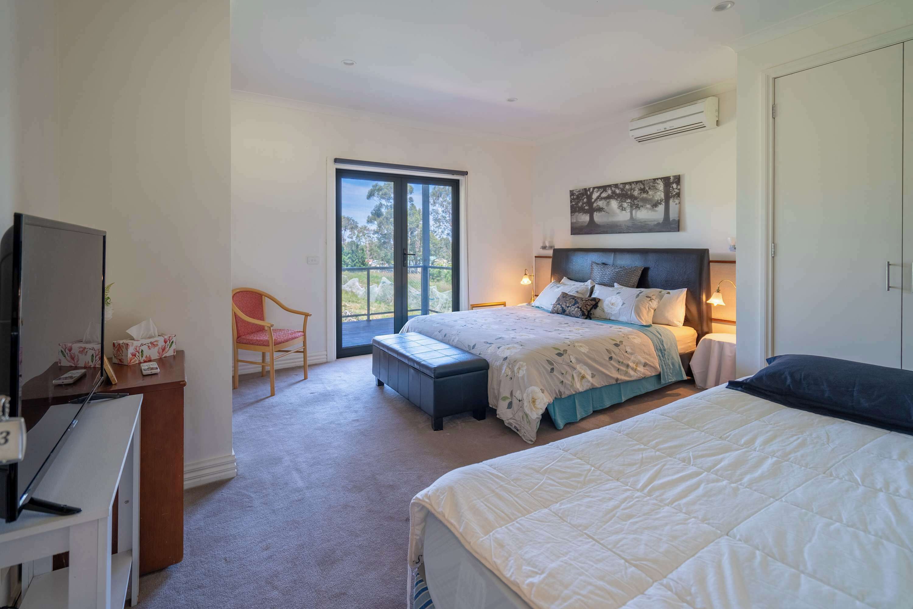 Bedroom with 1 queen bed, 1 single bed, and private balcony