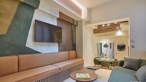 Ein modernes Wohnzimmer mit einer Eckcouch, einem Couchtisch und einem Essbereich mit Tisch und Stühlen.