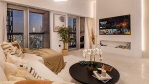 Ein modernes Wohnzimmer mit einem großen Bett, einem Couchtisch und einem an der Wand montierten Fernseher.