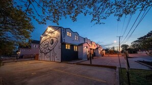 A building with a unique artistic facade, a parking lot, and a clear sky. - OV Mosaic - River Suite (Norfolk)