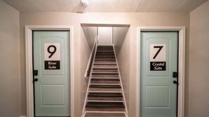 A hallway with two doors labeled '9 River Suite' and '7 Crystal Suite'. - OV Mosaic - River Suite (Norfolk)