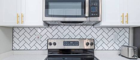 Una cocina con microondas, horno y tostadora de acero inoxidable.