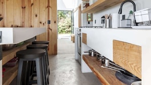 Una cocina moderna con detalles de madera, taburetes de bar y una isla central.