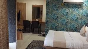Habitació d'hotel amb dos llits, una taula, una cadira i un mirall.
