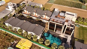 A large, modern house with multiple levels, a swimming pool, and surrounding landscaped gardens. - Villasita (Haridwar)