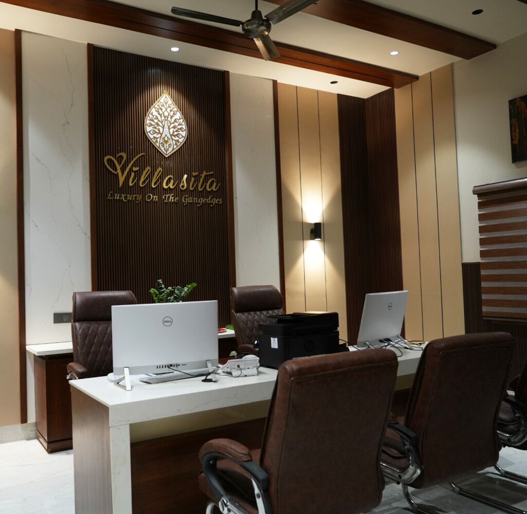 Una oficina moderna con dos escritorios, sillas de cuero y una pared decorativa con el texto "Villa Sita Luxury On The Ganggedges".