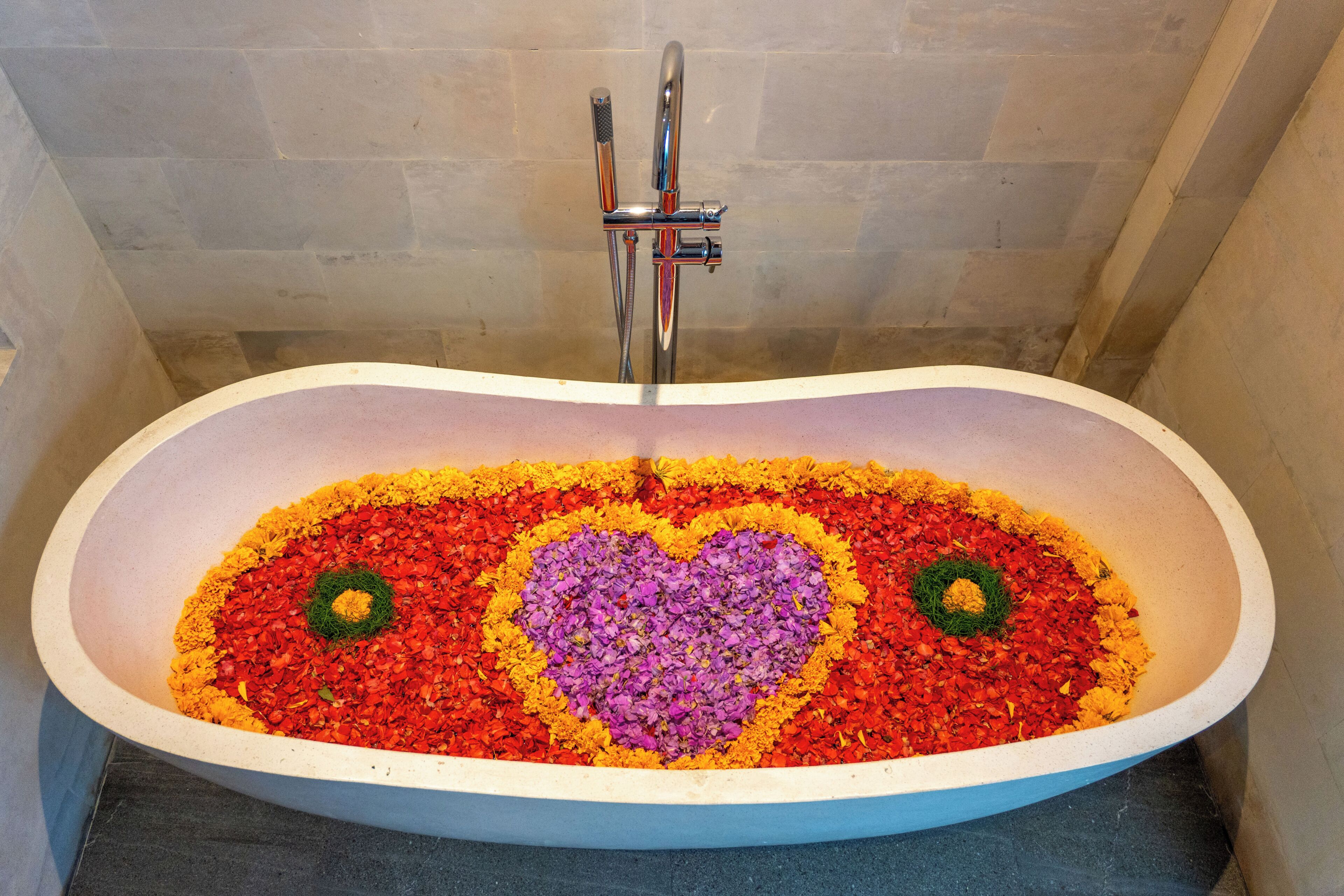 A bathtub with a heart-shaped flower arrangement.
