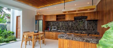 Una cocina moderna con armarios de madera, encimera de granito y estufa integrada.