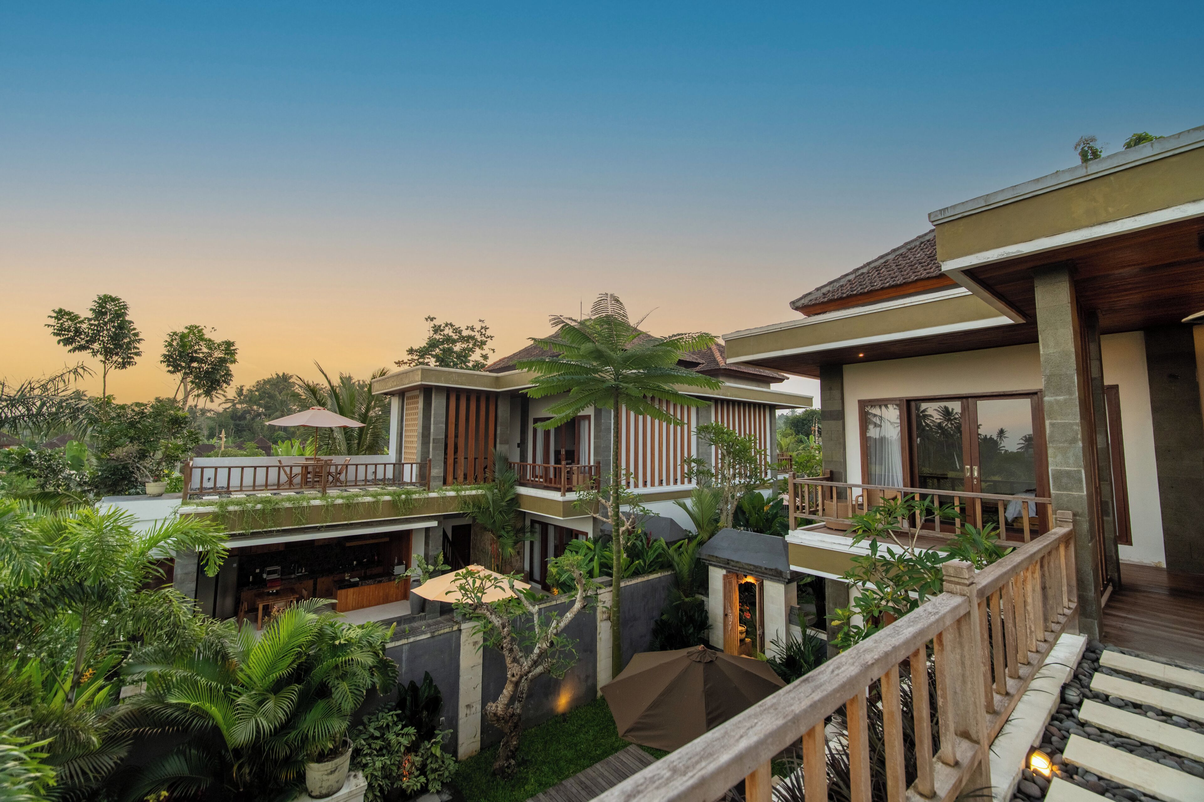 Ein modernes Resort mit mehreren Gebäuden, Außenbereichen zum Sitzen und üppiger Bepflanzung.