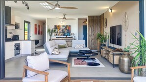 A modern living room with a sofa, chairs, a coffee table, and a TV.