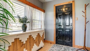 A room with a window, a door, and a plant on a window sill. - Secluded Home w/ Lake View in Delton! (Delton)