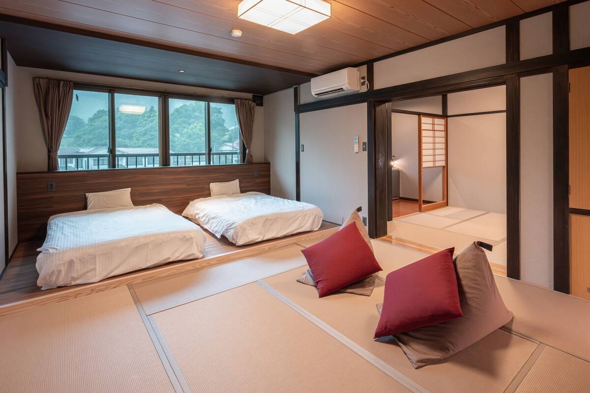 A traditional Japanese-style room with two beds, tatami mats, and sliding doors.