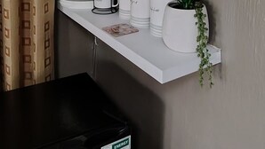 A kitchen with white shelves holding glassware, a coffee maker, and a small plant. - Indulgent Escape, Jet Bath, Stunning Views & Boma Firepit -Retreat from the City (Roodepoort)