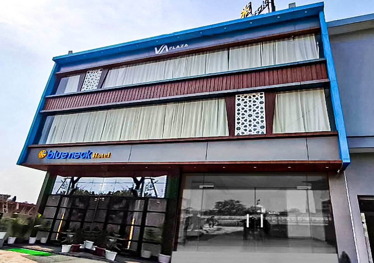 A hotel with a blue facade, a sign for 'Blueneck Hotel', and a visible entrance.